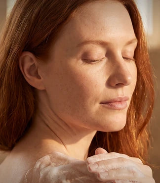 A woman washing her shoulder with castile soap